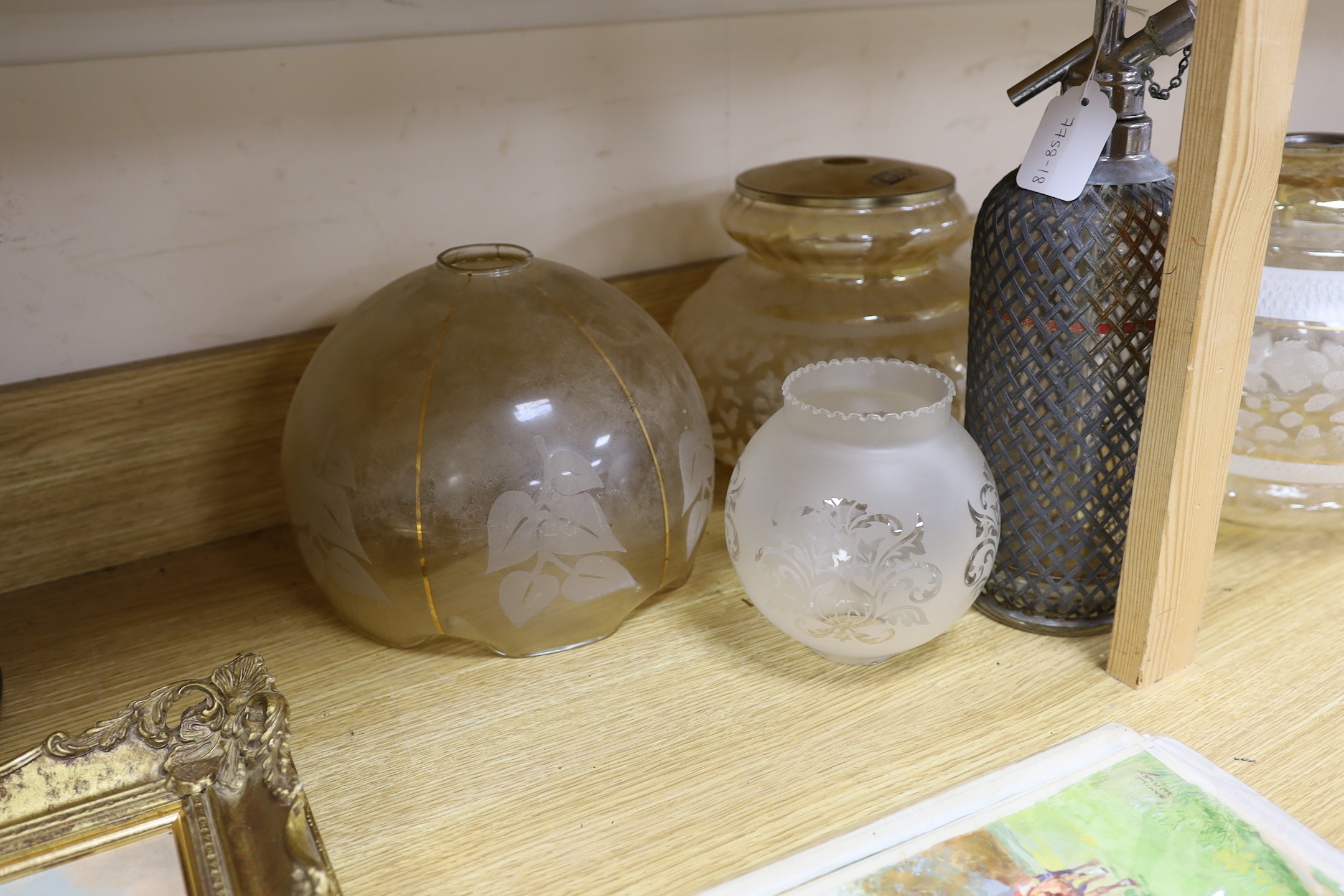 A group of glass lamp shades and an electroplate mounted syphon